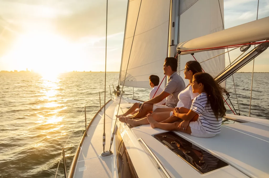 A family of four enjoying a sunset on a sailboat in Southeast Florida near Boca Raton.